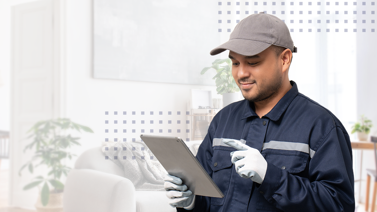 A field tech in uniform smirking while looking at a tablet