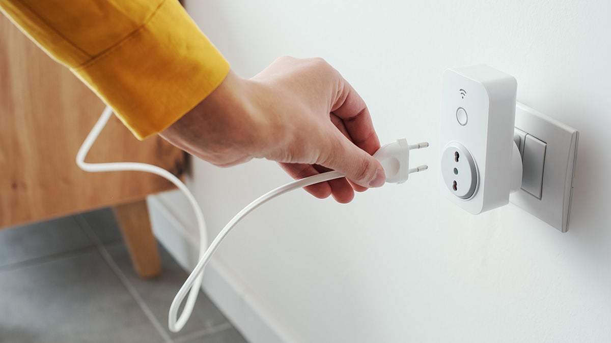 Woman plugging a device into a smart plug