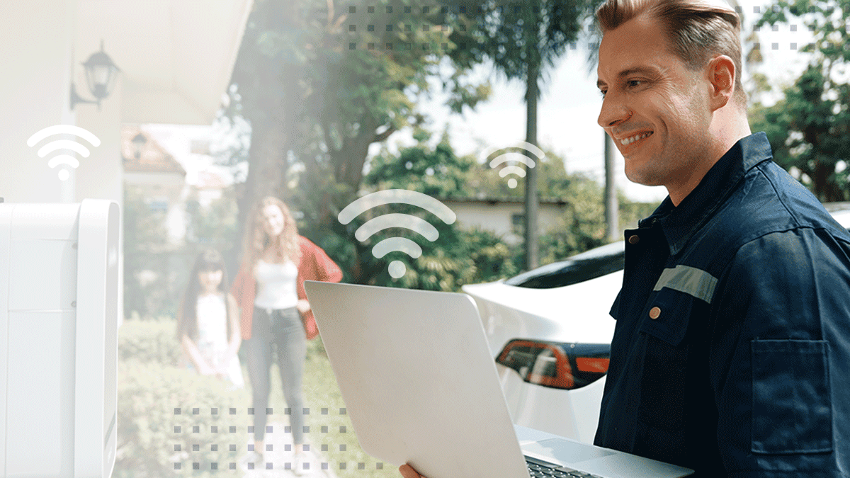 A smiling technician with a laptop setting up Wi-Fi for a happy subscriber
