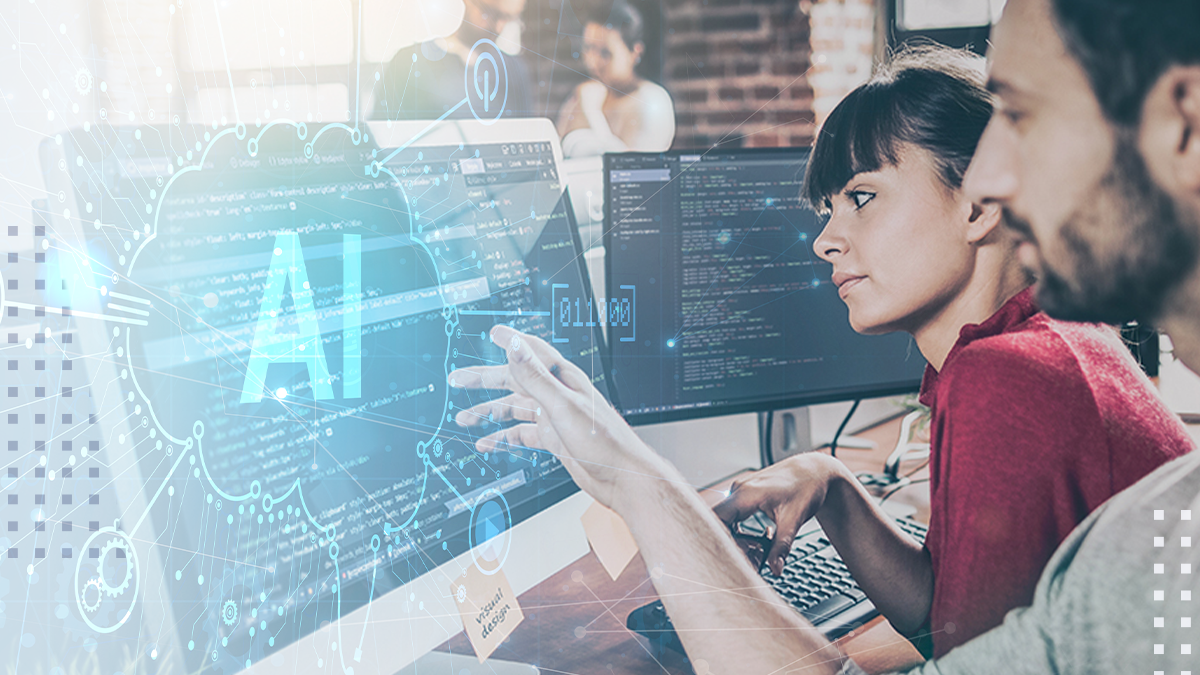 Two colleagues work together at a computer workstation focused on artificial intelligence development