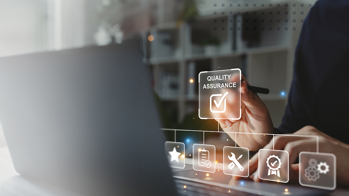 Hand of businessman holding a pen pointing to Quality Assurance icon