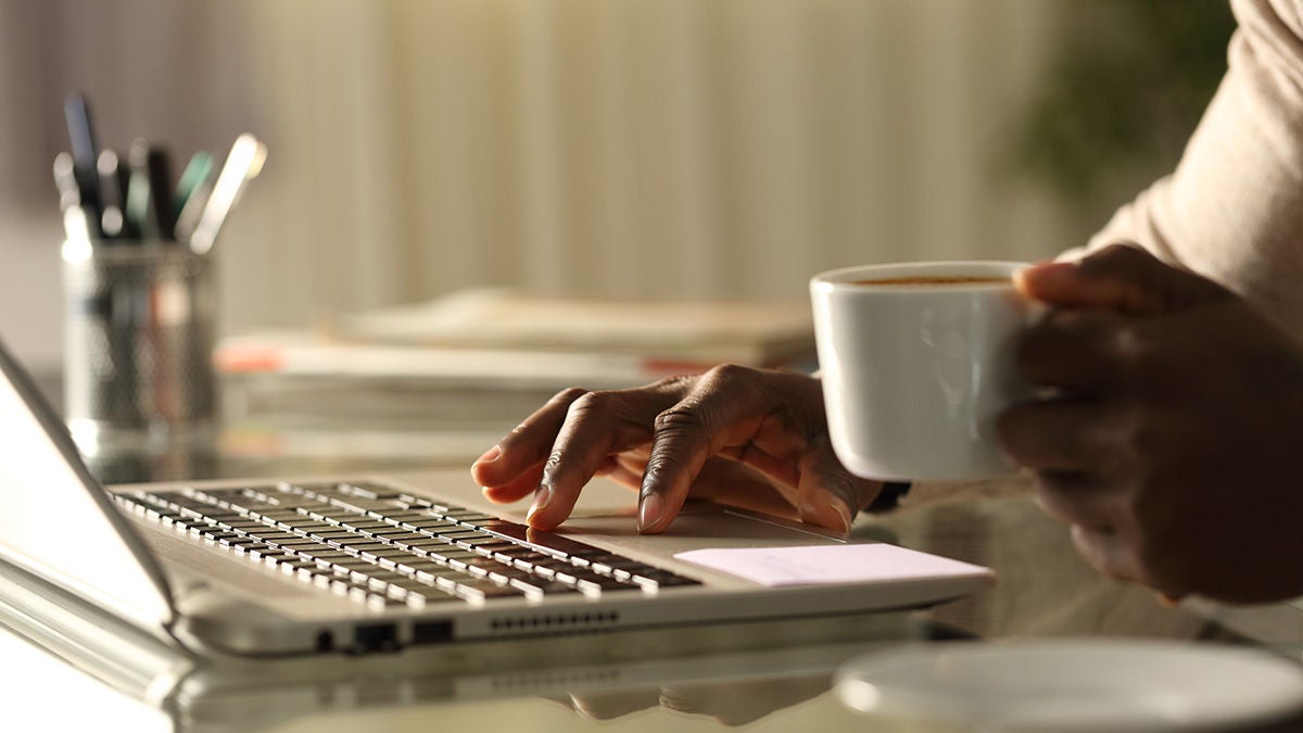 hands on laptop and coffee cup