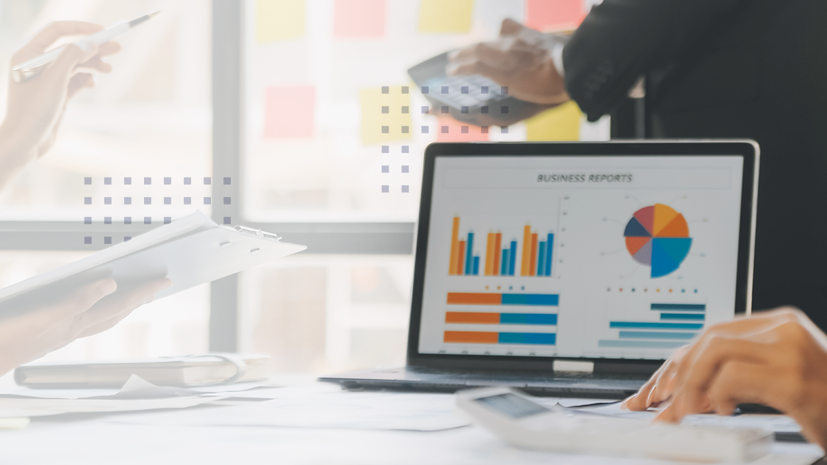 A laptop on a table displaying data driven strategies and analytics charts during a meeting