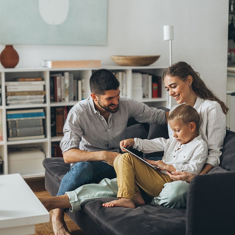 Family on sofa with device