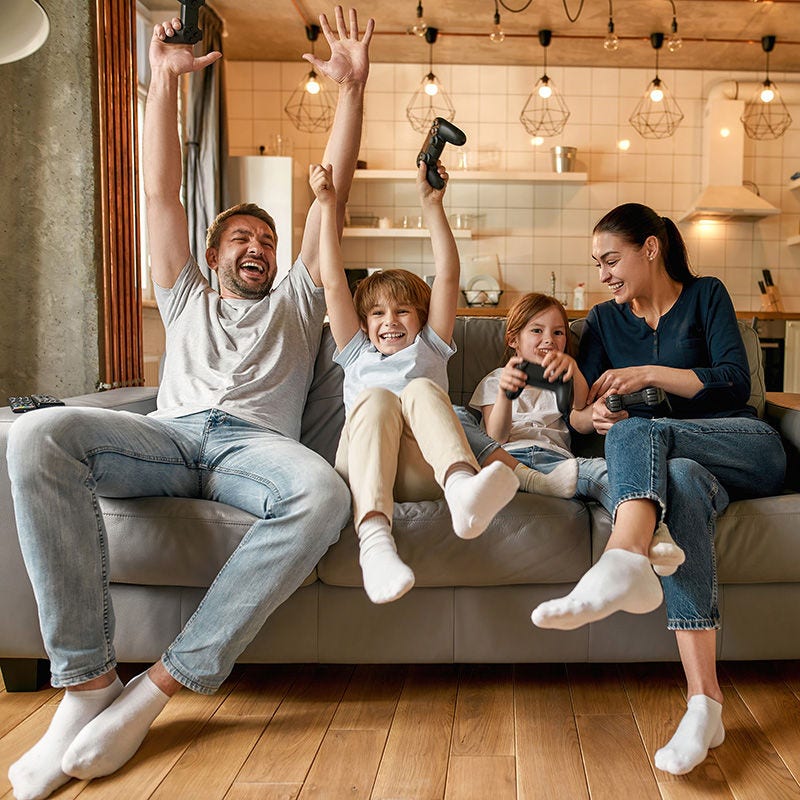 happy family with devices on sofa