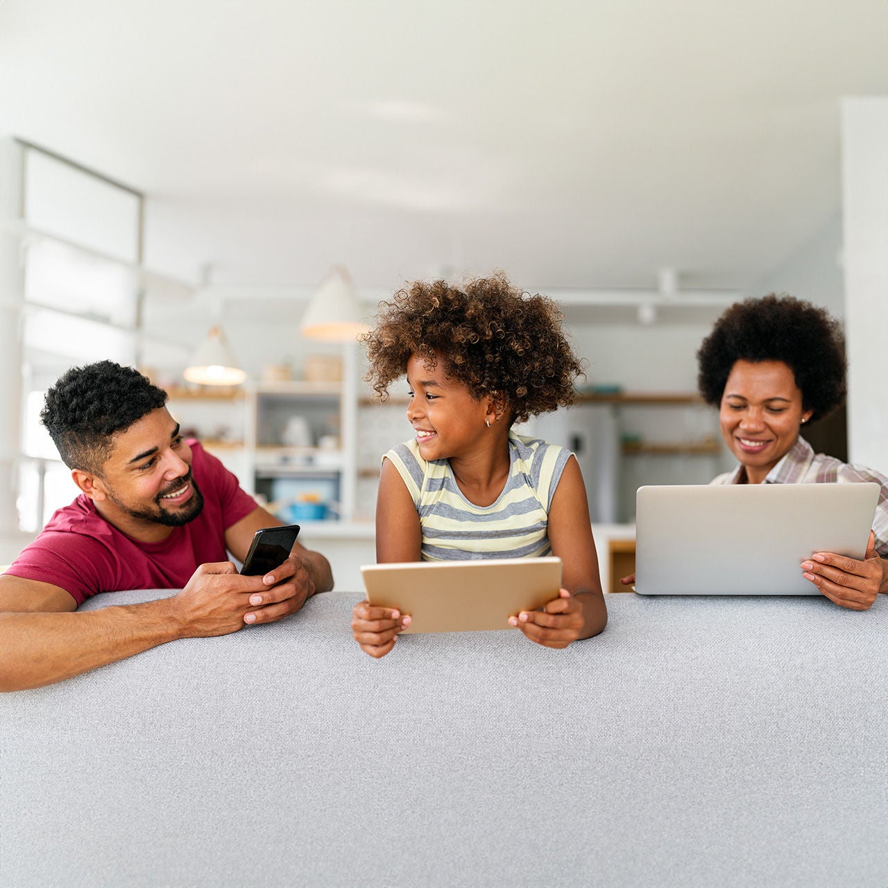 Smiling family at home with devices