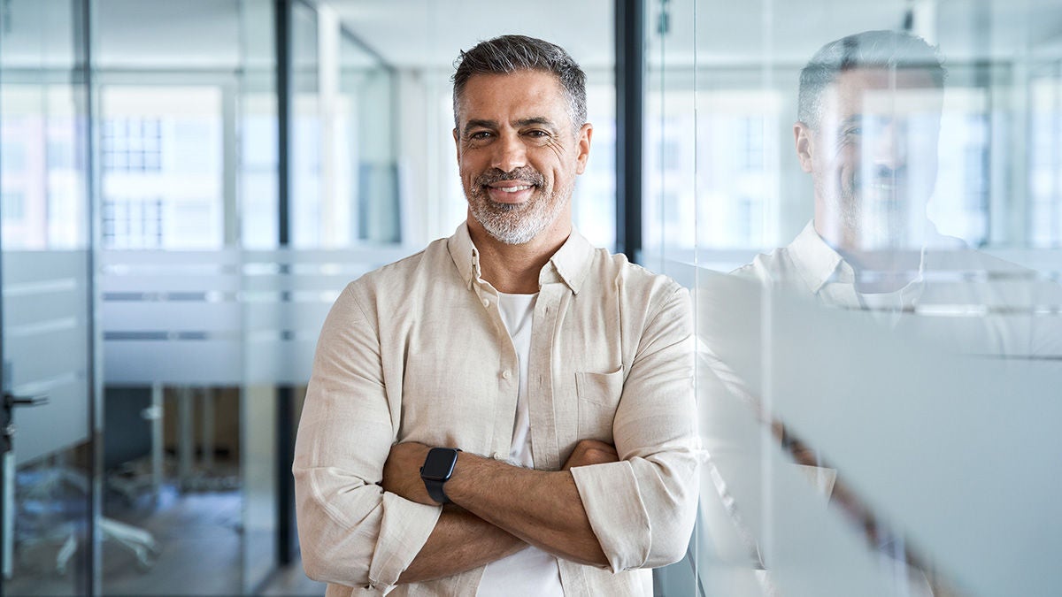 businessman with crossed arms on blur office background with copy space