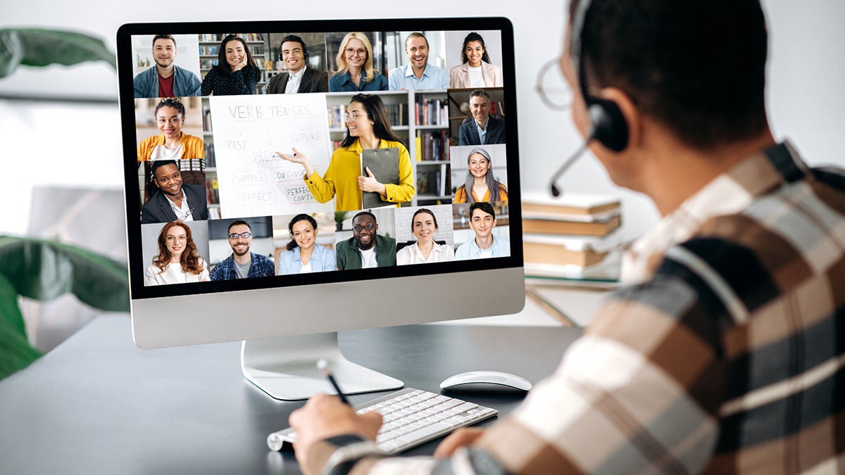 Man with headset watching computer with virtual training class