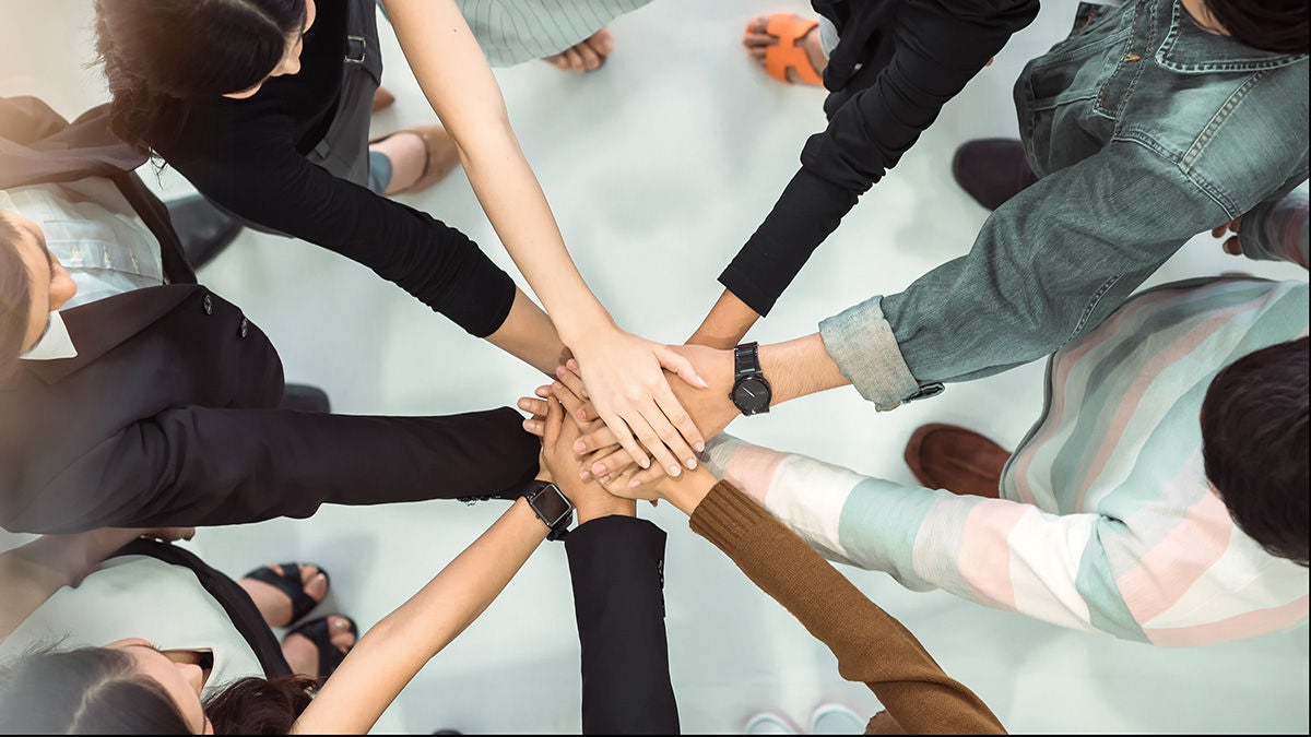 group of hands clasped together 