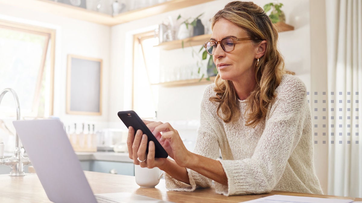 woman on phone while having coffee at the kitchen counter