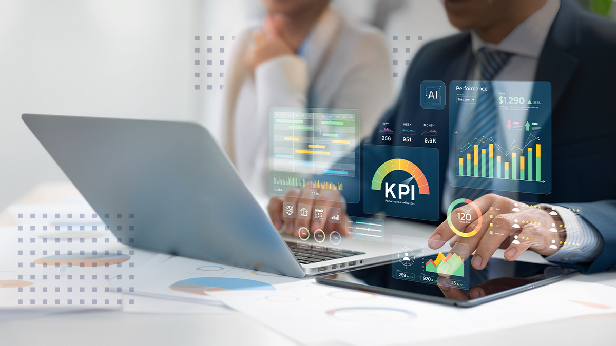 A man in an office working on his laptop and tablet with abstract KRI and data metrics overlaid