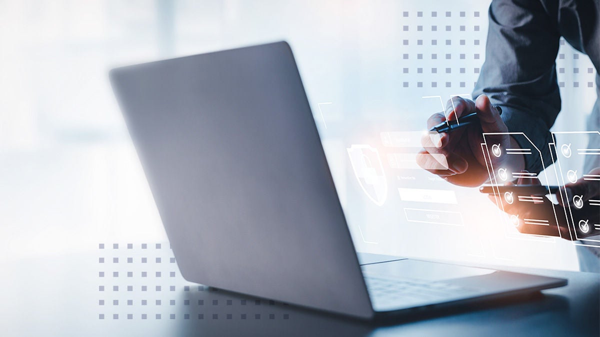 A man using an integrated software platform on a laptop