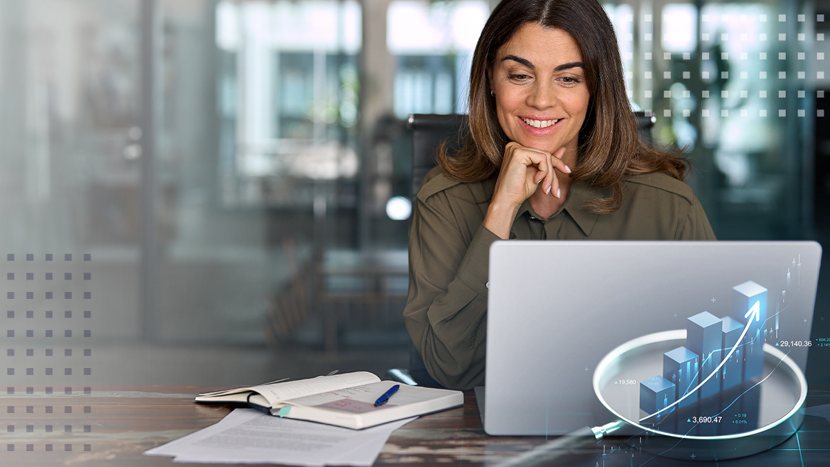 Happy businesswoman looking at the laptop screen, working on financial charts and reports in the office
