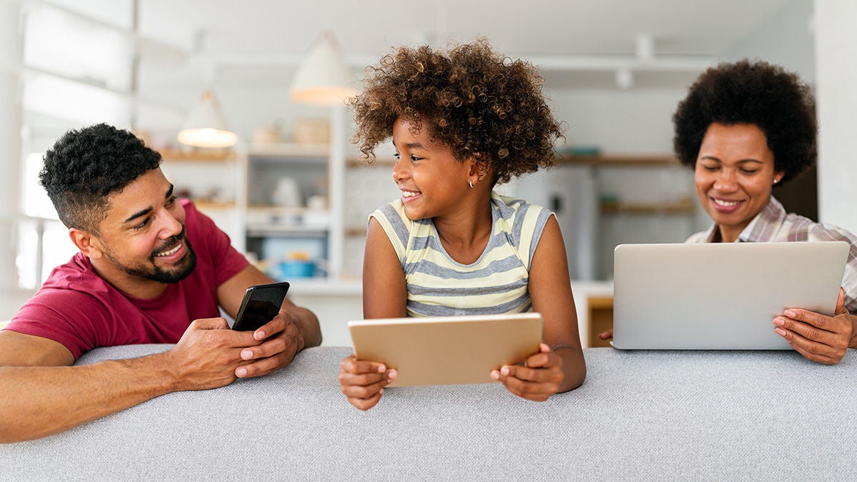 family on couch using device