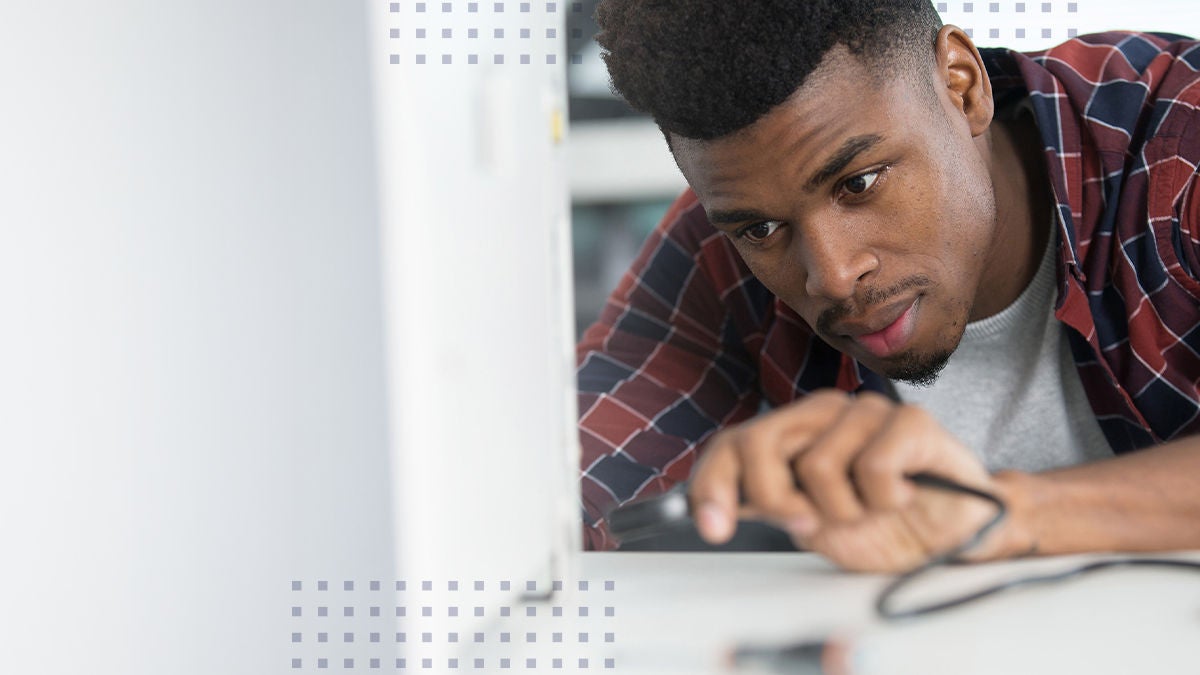 young man working on computer connecting cord network engineer