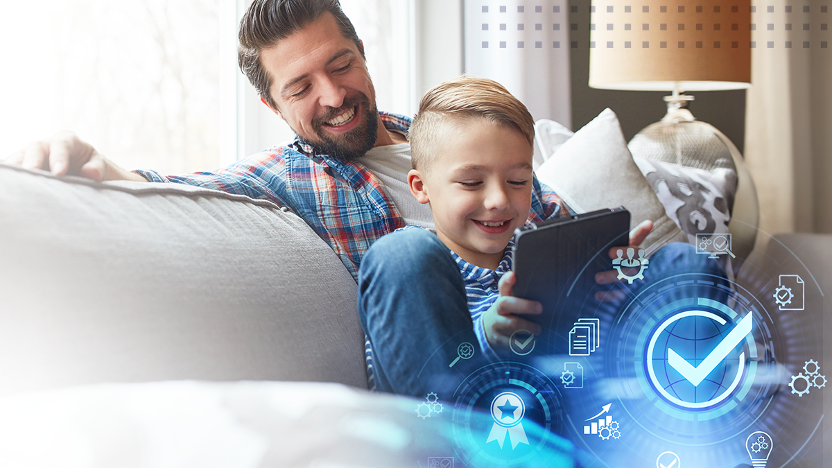 The child is learning on a tablet while the dad is looking at the screen