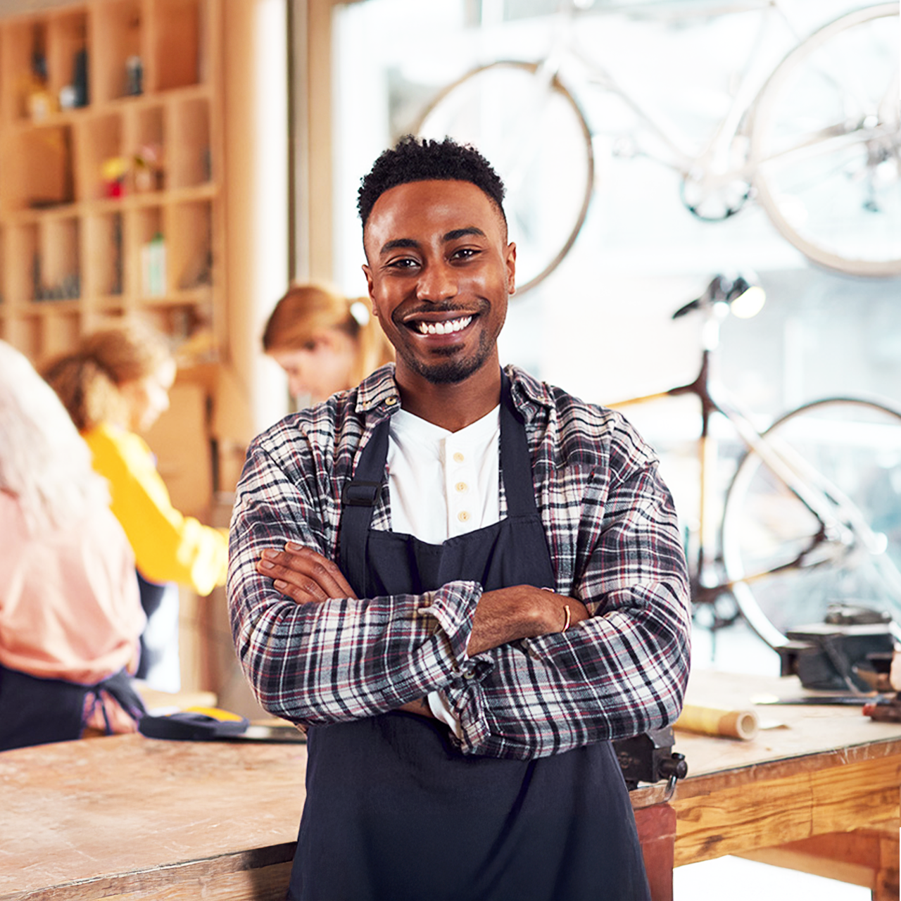 Small business bike shop business owner smiling with employees in background