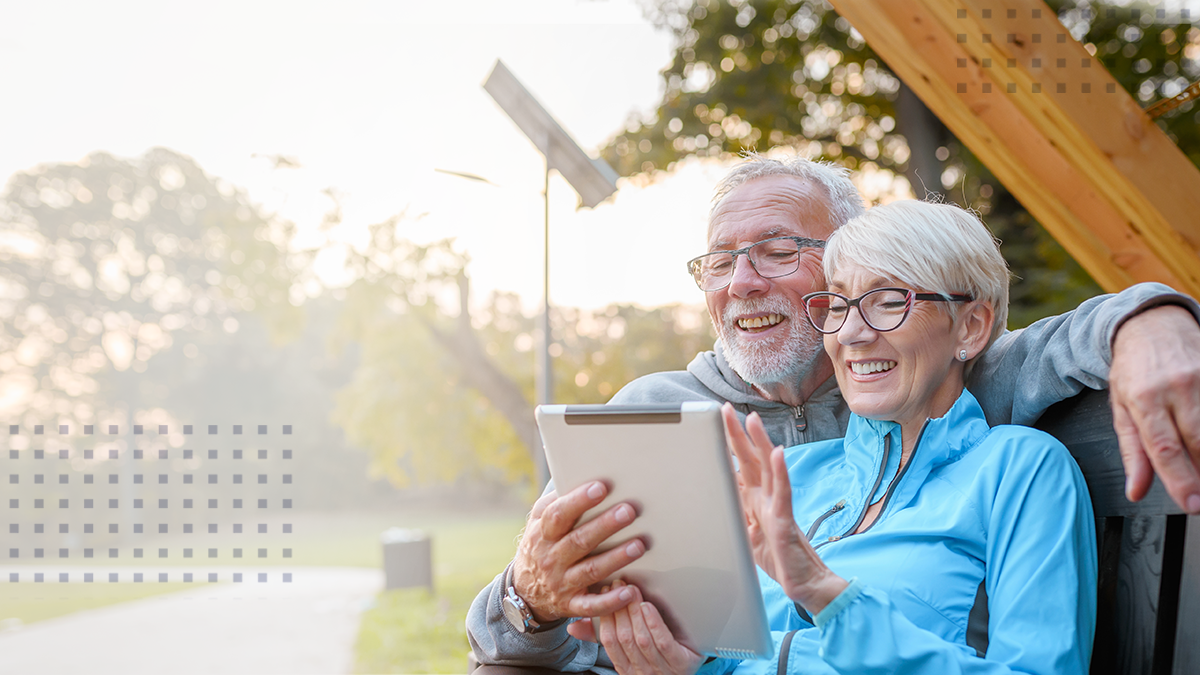 happy older couple outdoors on ipad