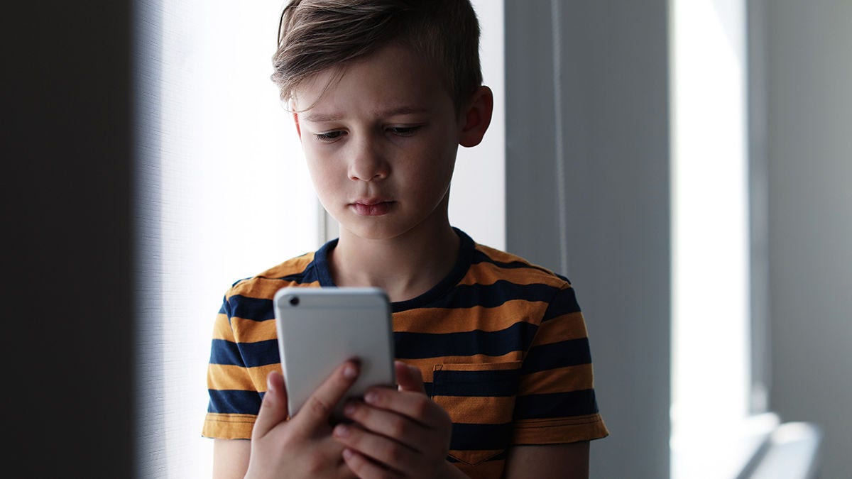 sad child looking at smartphone