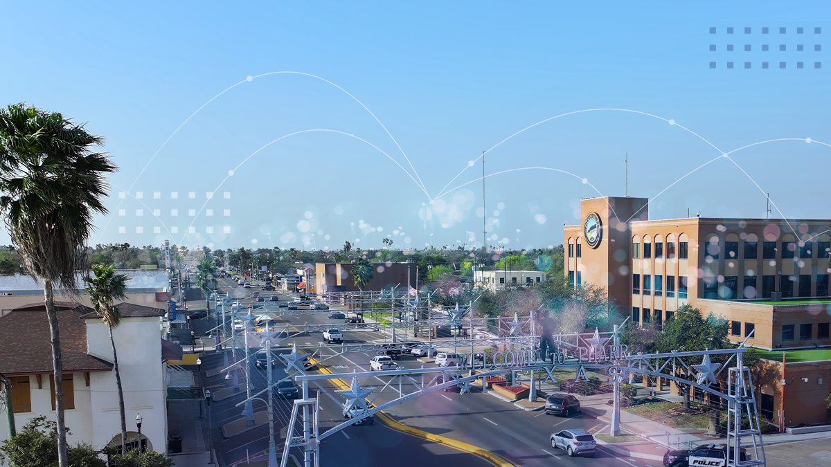 An aerial view of a downtown community with abstract broadband network icons overlaid