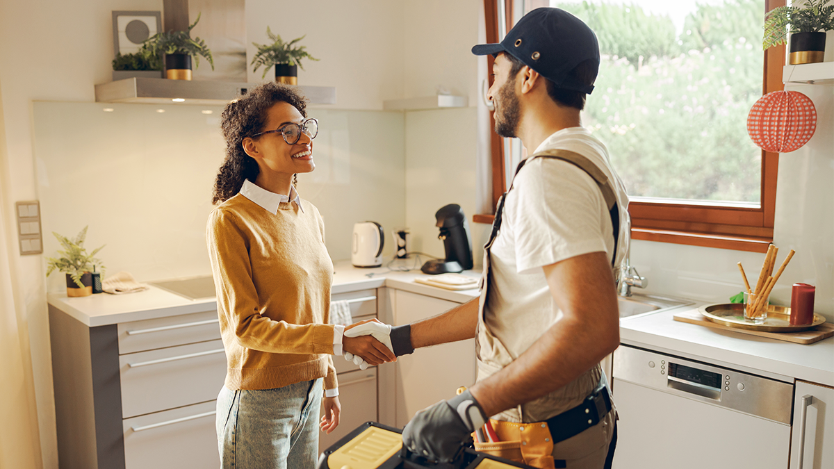 Technician shakes woman's hand in home doing service 